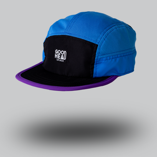 The ANGA cap by GOOD HEAD SPACE. Blue and black with purple trim on the brim. Nylon and mesh fabric. A sporting lifestyle cap great for running, hiking trails, skateboarding or leisure wear. 